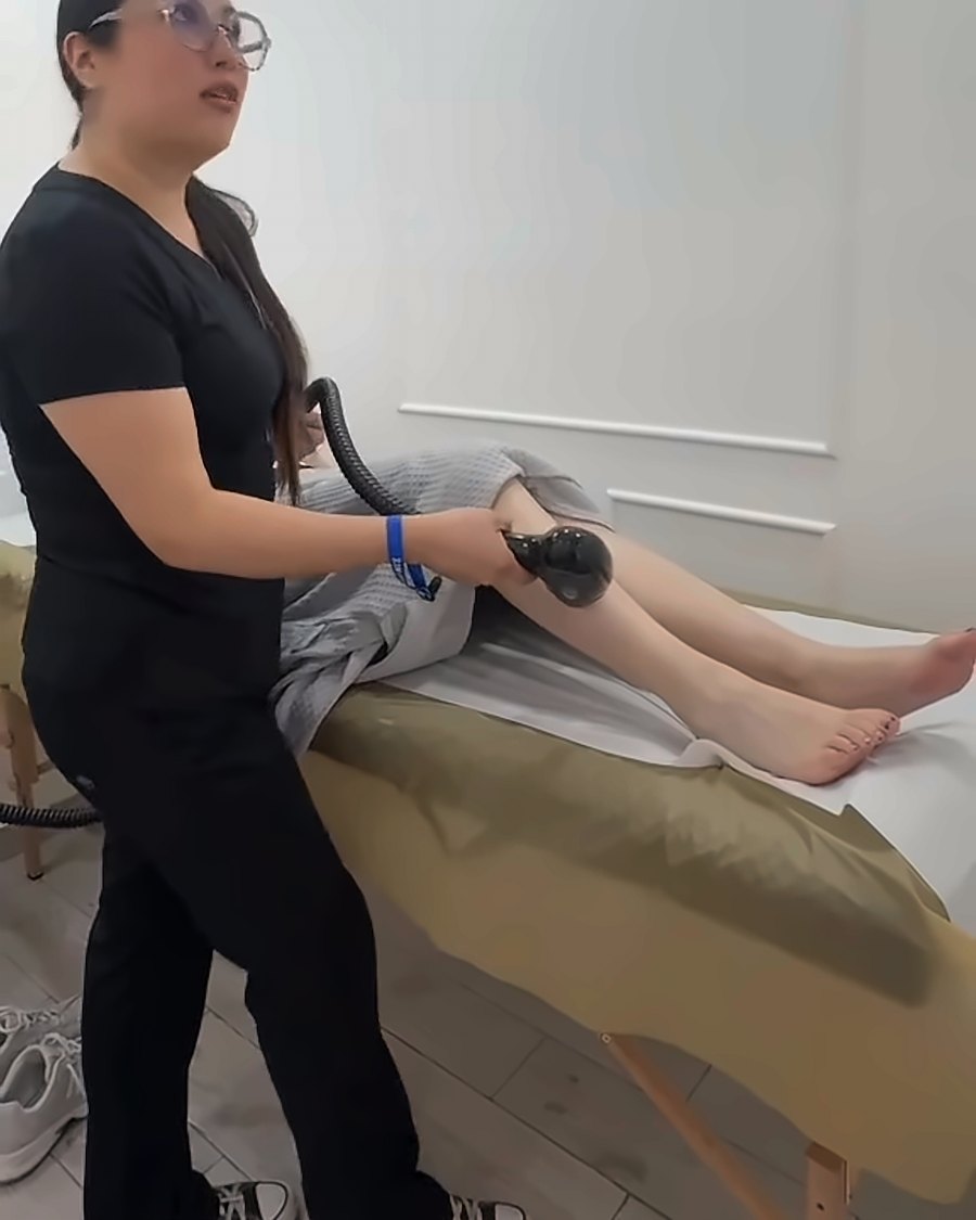 Especialista aplicando tratamiento corporal en cabina